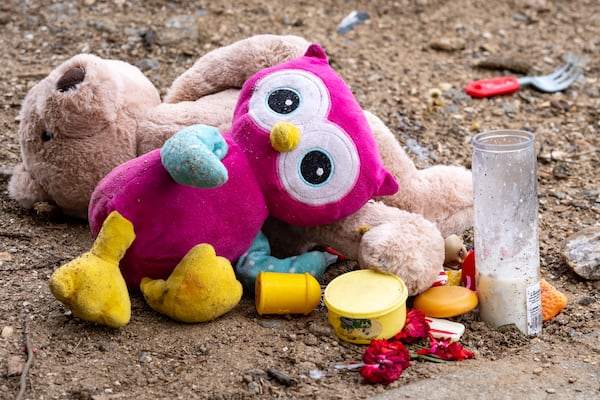 A small makeshift memorial is placed on a curb in the parking lot of the Budgetel Inn & Suites in Cobb County, where 9-month-old Aziah McDougle was killed. (Ben Hendren for the AJC)