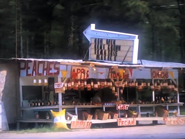 The Peches Fruit Stand, as it was in 1991, before its famed misspelling, shown here in a screen photograph of the opening scenes of “My Cousin Vinny,” which was filmed in Putnam and Jasper counties. (Joe Kovac Jr./AJC)