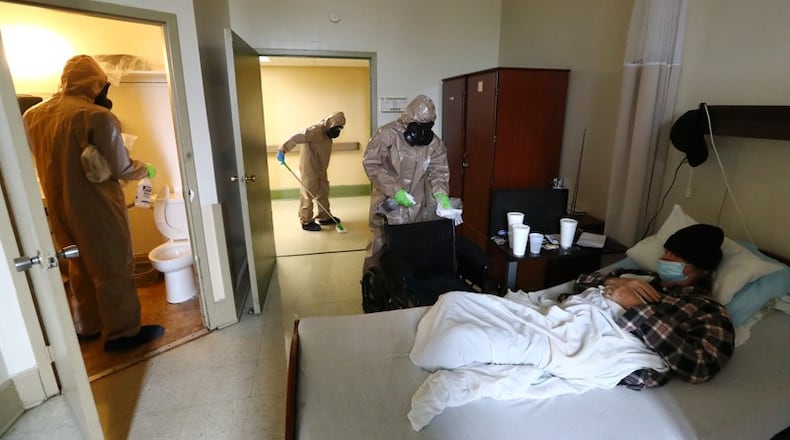 Members of the Georgia Army National Guard  disinfect a resident's room at the Legacy Transitional Care last month in Atlanta.