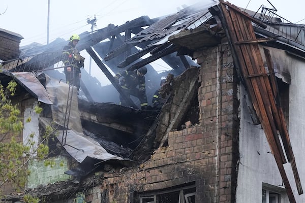 Firefighters work in a destroyed apartment building after a Russian attack in Kyiv, Ukraine, early Thursday, July 10, 2025. (AP Photo/Efrem Lukatsky)
