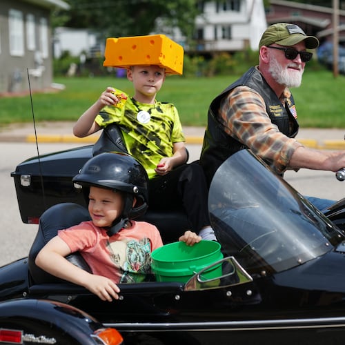 U.S. Rep. Derrick Van Orden rides his motorcycle in a Labor Day parade with his grandsons, Teddy and Henry, Monday, Sept. 7, 2026, in Readstown, Wis. (AP Photo/Ellen Schmidt)