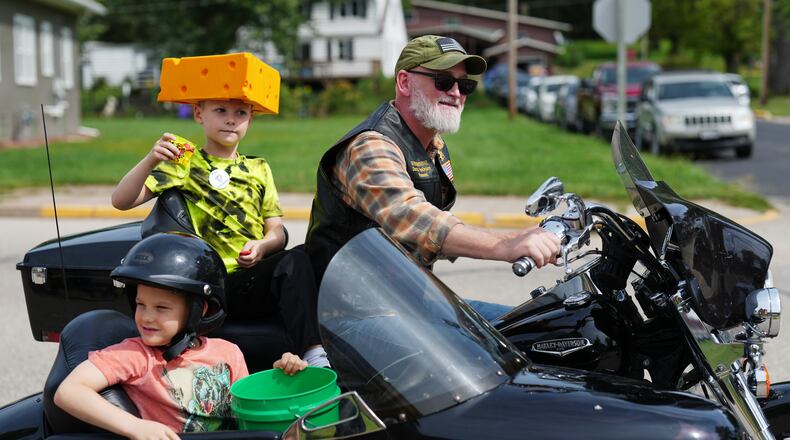 U.S. Rep. Derrick Van Orden rides his motorcycle in a Labor Day parade with his grandsons, Teddy and Henry, Monday, Sept. 7, 2026, in Readstown, Wis. (AP Photo/Ellen Schmidt)