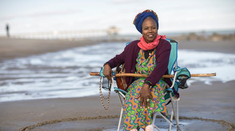 Julia Pearce, who's running for may of Tybee Island, sits in a full circle she drew around her beach chair. Pearce said she draws a circle as an acknowledgment to her community, her ancestors and a space for her friends to join her. (AJC Photo/Stephen B. Morton)