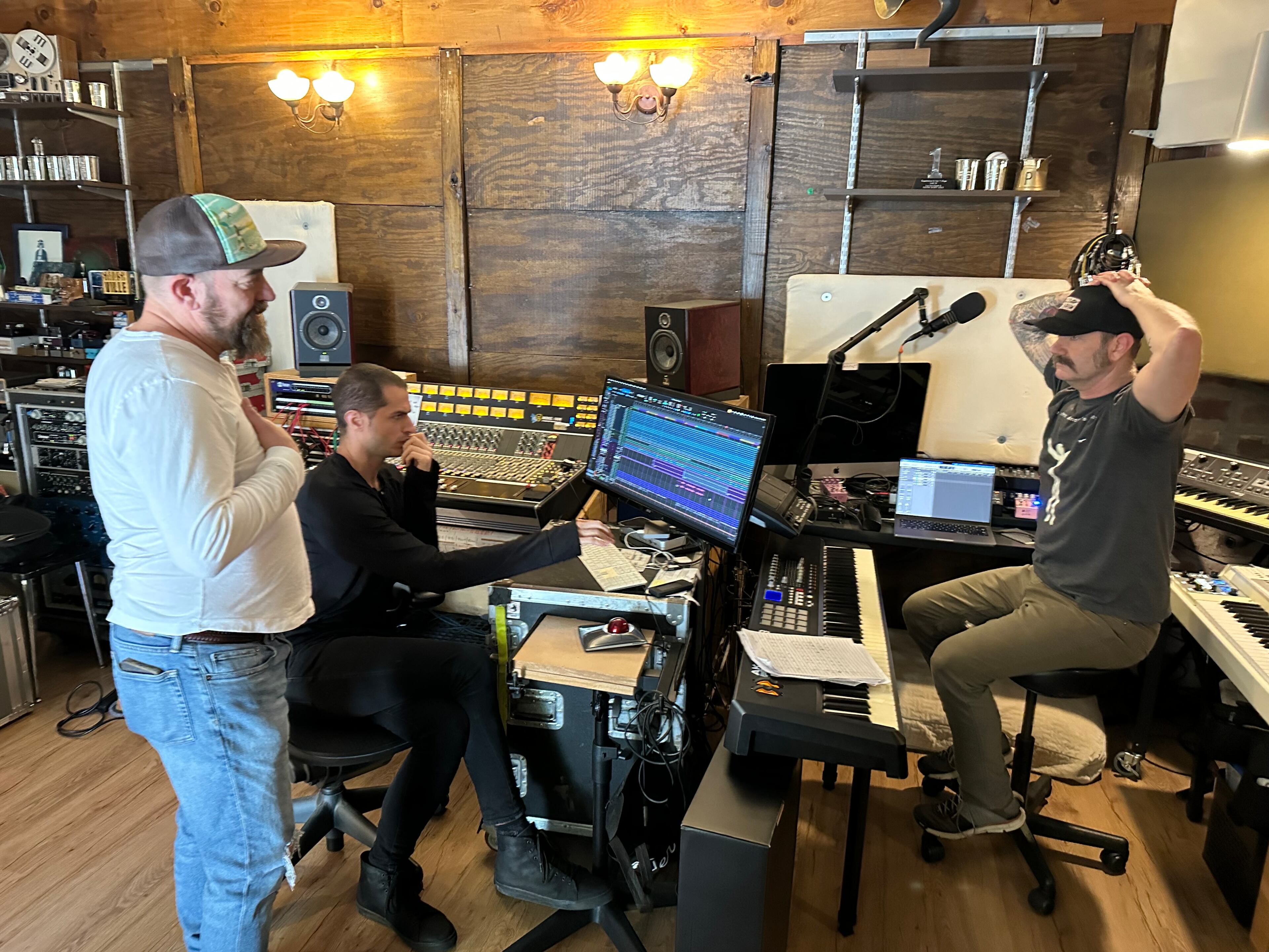 Kristian Bush (left) works on a song with engineer Luke Campolieta (center) and Brandon Bush (right) at his Decatur studio before his Eddie's Attic show on Sunday. (Rodney Ho/AJC)