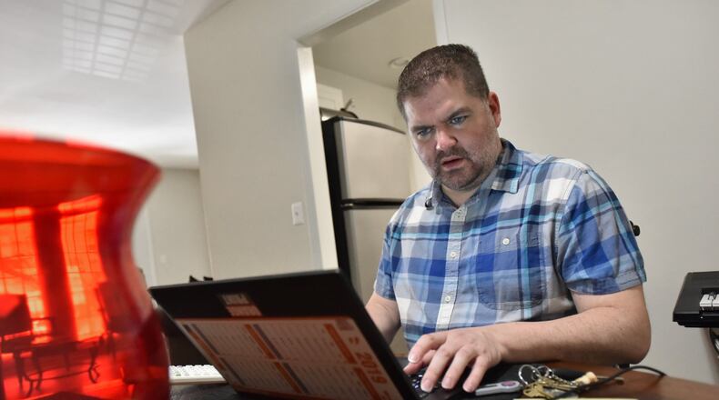 Patrick Hill works on his laptop at his apartment home in Sandy Springs. The CPA is now a full-time employee at Home Depot, but he worked contract jobs for a decade. HYOSUB SHIN / HSHIN@AJC.COM