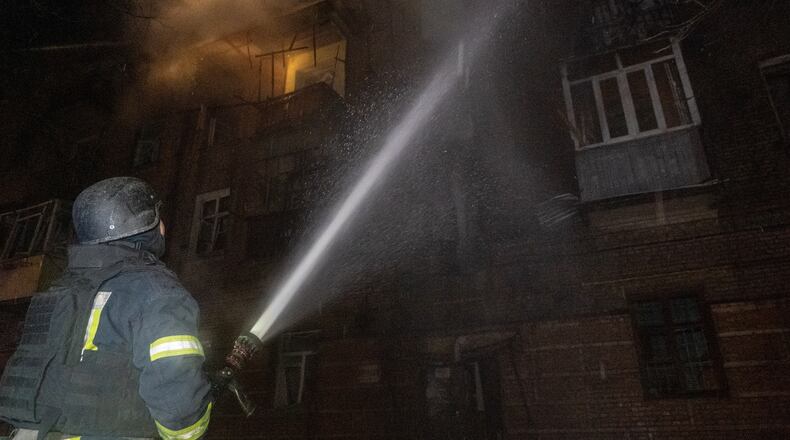 Emergency services personnel work to extinguish a fire following a Russian attack in Kharkiv, Ukraine, Saturday, Jan. 24, 2026. (AP Photo/Andrii Marienko)