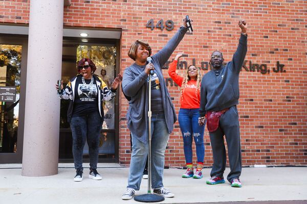 De’Leice Drane pumps her fist and chants before a food distribution drive at the King Center on Saturday, Nov. 15, 2025, in Atlanta. At least five other food drives occurred at locations in DeKalb County. (Abbey Cutrer/AJC)