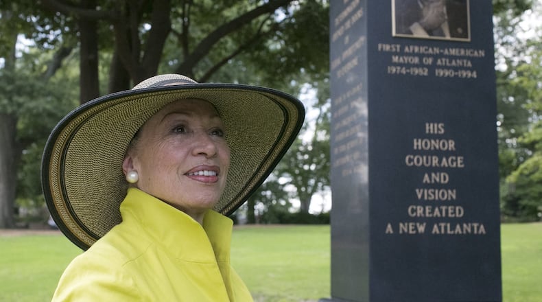 Valerie Jackson, the widow of Maynard Jackson, looks toward the Atlanta skyline, which the portrait of Maynard is facing, as she visited the 14.5-foot monument she erected on her husband’s gravesite at Oakland cemetery. BOB ANDRES /BANDRES@AJC.COM