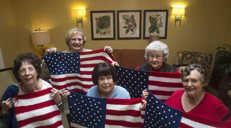 Nancy Harvey (from left), Rose Marie Holbein, Olive Ellner, Marjory Everett and Esther Solomon show American flag lap quilts that they knitted at Huntcliff Summit, an independent living facility in Sandy Springs, for wounded veterans in wheelchairs. The idea was originally Ellner’s (center), who said, “I had to find something to do for somebody that was meaningful.” Before this project, 90 year-old Ellner says that she hadn’t knitted in 50 years. CASEY SYKES / CASEY.SYKES@AJC.COM