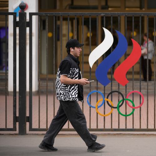 A man walks past a fence with Olympic Rings in front of the Russian National Olympic Committee building in Moscow, on Tuesday, July 7, 2026. (AP Photo/Pavel Bednyakov)