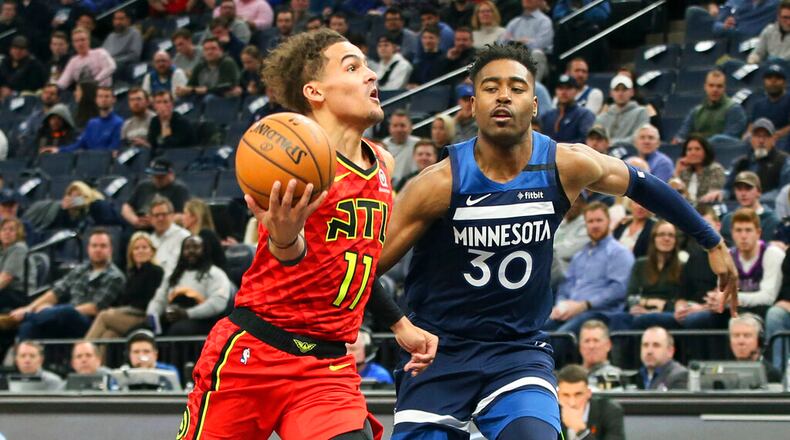 Hawks' Trae Young, left, drives past Minnesota Timberwolves' Kelan Martin in the second half of an NBA basketball game Wednesday, Feb. 5, 2020, in Minneapolis. The Hawks won 127-120. Young led the Hawks with 38 points. AP Photo/Jim Mone)