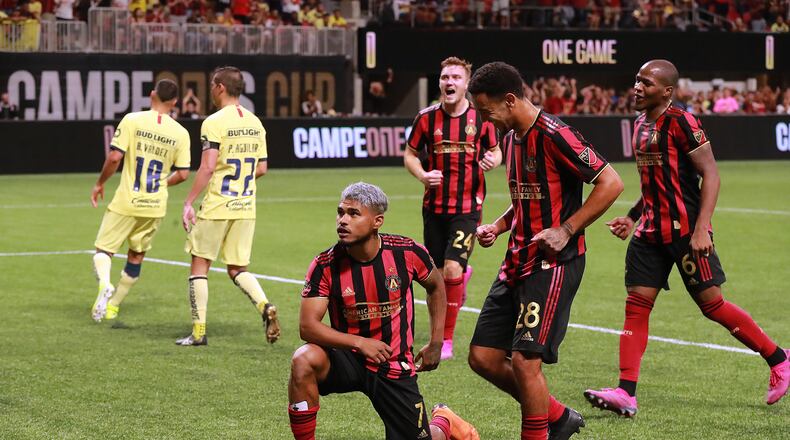 August 14, 2019 Atlanta: Atlanta United forward Josef Martinez strikes a pose for the fans after making what turned out to be the winning goal on a penalty kick for a 3-2 victory over Club America as teammates arrive to celebrate in the Campeones Cup on Wednesday, August 14, 2019, in Atlanta.   Curtis Compton/ccompton@ajc.com