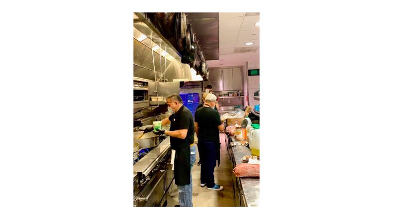 True Story Brands employees cook meals in the kitchen of Biltong Bar for the Frontline Dine initiative serving hospital  personnel at Children's Healthcare of Atlanta. COURTESY OF TRUE STORY BRANDS