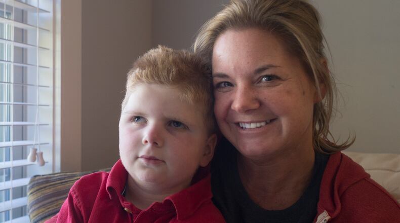 Tripp Halstead, 7, and Stacy Halstead pose for a portrait last month in their home in Jefferson, Ga. Tripp, who suffered a traumatic brain injury five years ago when a tree limb fell on him at his day care, was rushed to the hospital Monday. He was expected to retrun home Wednesday. (CASEY SYKES, CASEY.SYKES@AJC.COM)