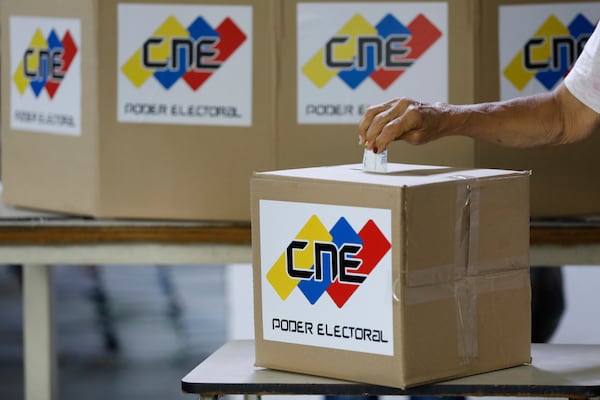 A woman casts a mock vote during a rehearsal for the upcoming regional election, in Caracas, Venezuela, Saturday, May 10, 2025. (AP Photo/Cristian Hernandez)