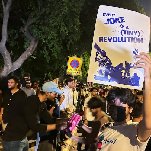 A protestor holds a placard with the message "Every Joke is a Tiny Revolution" during a demonstration demanding educational reforms as part of the Cockroach Janta Party's ongoing protest movement in New Delhi, India, Thursday, July 23, 2026. (AP Photo/Verda Sabzwari)