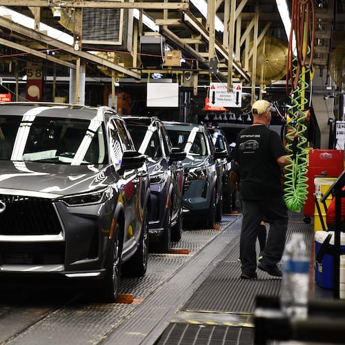 A worker walks past a line of Infiniti SUVs on a production line at the Nissan Smyrna Vehicle Assembly Plant, Thursday, April 16, 2026, in Smyrna, Tenn. (AP Photo/Kristin M. Hall)