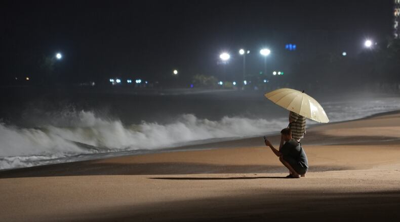 People watch rough waves caused by Typhoon Kalmaegi in Khanh Hoa, Vietnam, Thursday, Nov. 6, 2025. (AP Photo/Hau Dinh)