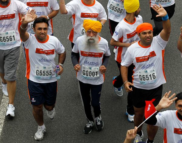 FILE - Centenarian marathon runner Fauja Singh, 101, center, originally from Beas Pind, in Jalandhar, India but who now lives in London, runs in a 10-kilometer race, part of the annual Hong Kong Marathon, in Hong Kong Sunday, Feb. 24, 2013. (AP Photo/Kin Cheung, File)
