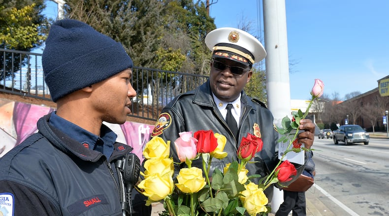 Sgt. Brenton Small and Interim Chief Joel Baker talk before handing out roses to motorists in this 2015 file image.