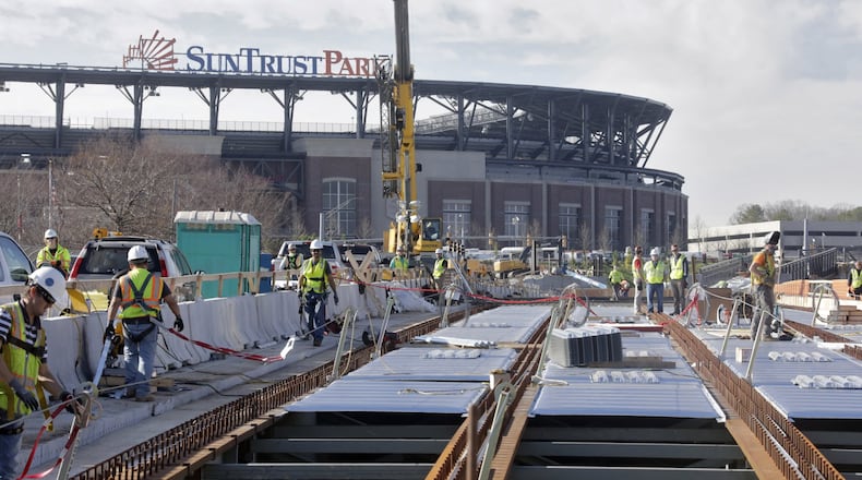 The elevated walkway over Windy Ridge Parkway to SunTrust Park is under construction and is one of the projects for which the Braves are seeking reimbursement from Cobb taxpayers. There is an on-going dispute between the county and Braves as to whether taxpayers are responsible for roads, bridges and other pedestrian improvements in and around the SunTrust Park development. BOB ANDRES /BANDRES@AJC.COM
