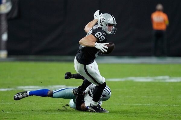 Raiders tight end Brock Bowers (center, with ball) gets taken down by Cowboys cornerback DaRon Bland during the second half Monday, Nov. 17, 2025, in Las Vegas. Bowers had a team-high seven catches for 72 yards in the loss to Dallas. (John Locher/AP)
