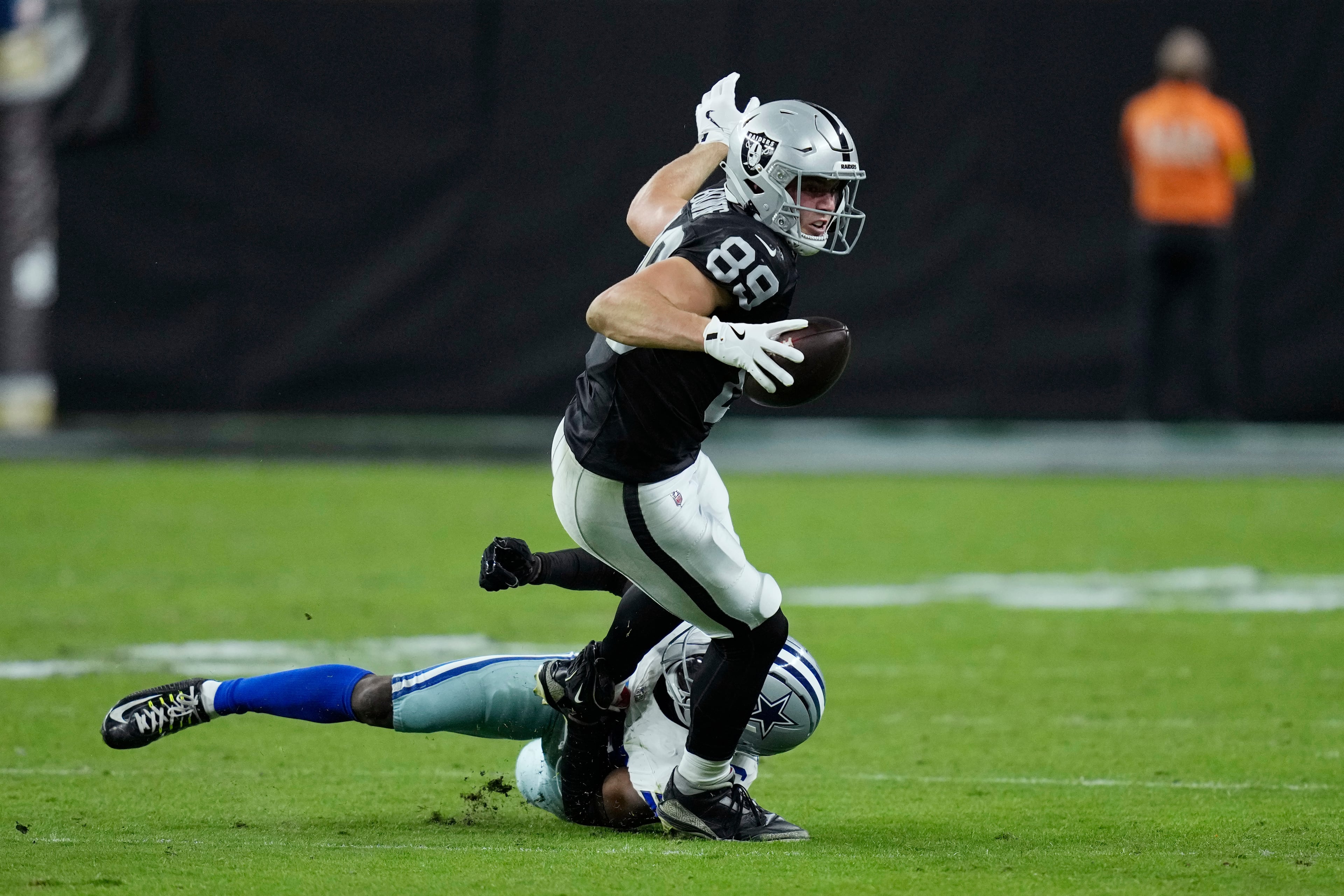 Raiders tight end Brock Bowers (center, with ball) gets taken down by Cowboys cornerback DaRon Bland during the second half Monday, Nov. 17, 2025, in Las Vegas. Bowers had a team-high seven catches for 72 yards in the loss to Dallas. (John Locher/AP)