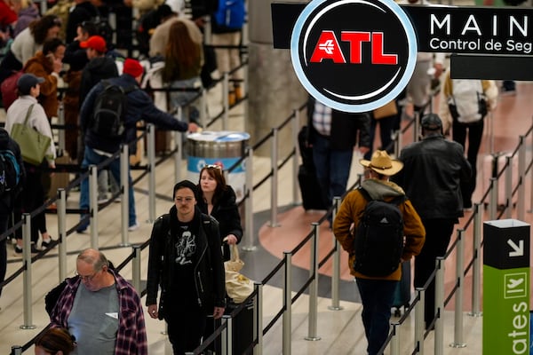 FILE - Travelers move through Hartsfield-Jackson Atlanta International Airport, Friday, Dec. 20, 2024, in Atlanta. (AP Photo/Mike Stewart, File)