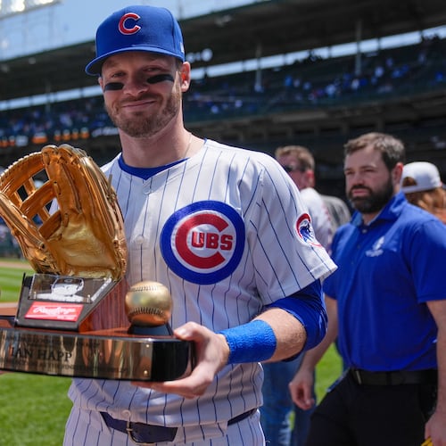 FILE - Chicago Cubs' Ian Happ (8) holds his Gold Glove Award trophy before a baseball game against the Cincinnati Reds, Saturday, May 31, 2025, in Chicago. (AP Photo/Erin Hooley, File)