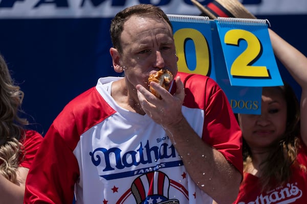 Competitive eater Joey Chestnut eats hot dogs during the 2025 Nathan's Famous Fourth of July hot dog eating contest in the Coney Island section of the Brooklyn borough of New York, Thursday, July 4, 2025. (AP Photo/Yuki Iwamura)
