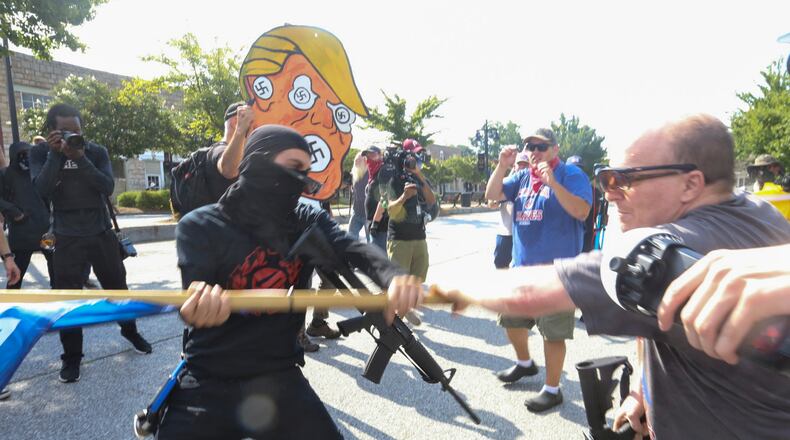 8/15/20 - Stone Mountain, GA - Counter protesters scuffle with  protesters as several far-right groups, including militias and white supremacists, rally Saturday in the town of Stone Mountain, and a broad coalition of leftist anti-racist groups organized a counter-demonstration there after local authorities closed Stone Mountain park.   Jenni Girtman for the Atlanta Journal Constitution