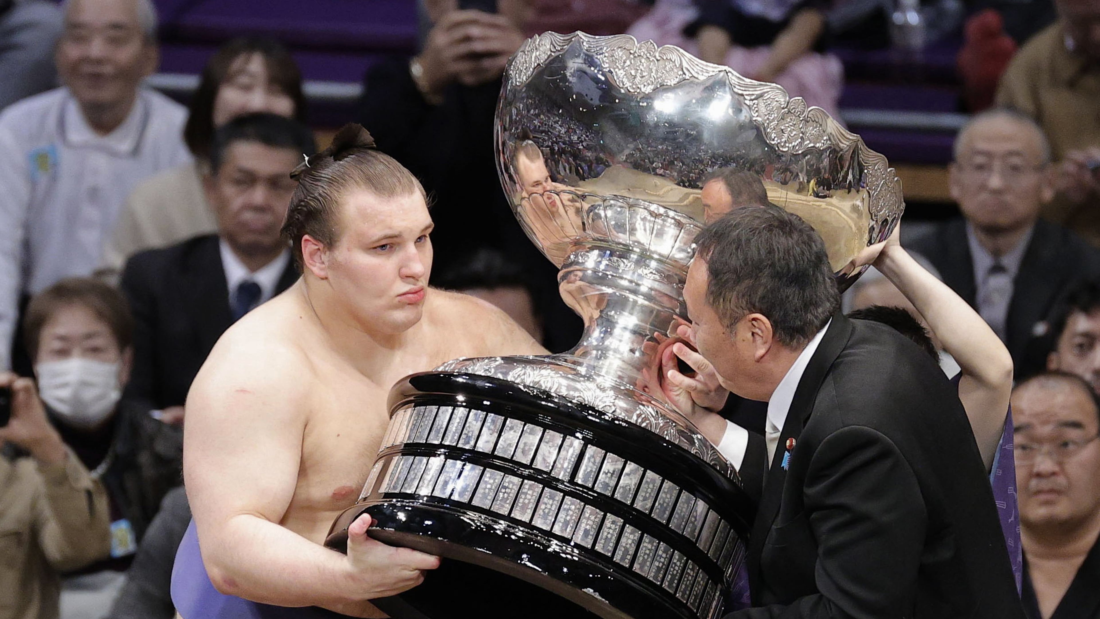 Ukrainian Aonishiki, left, receives a trophy after winning the Kyushu Grand Sumo Tournament in Fukuoka, western Japan, Sunday, Nov. 23, 2025. (Kyodo News via AP)