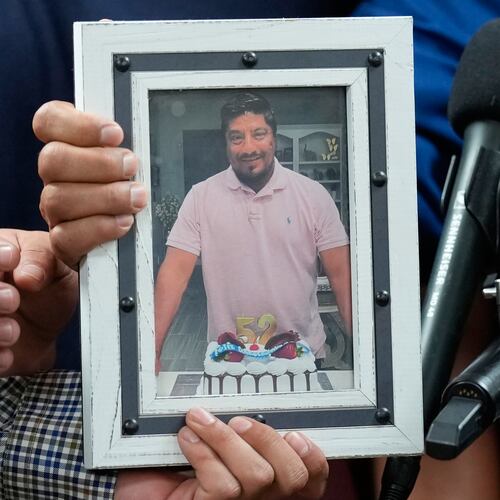 Ronaldo Salgado and Lorenzo Jr., sons of Lorenzo Salgado Araujo, hold a photograph of their father during a news conference Wednesday, July 8, 2026, in Houston. (AP Photo/David J. Phillip)