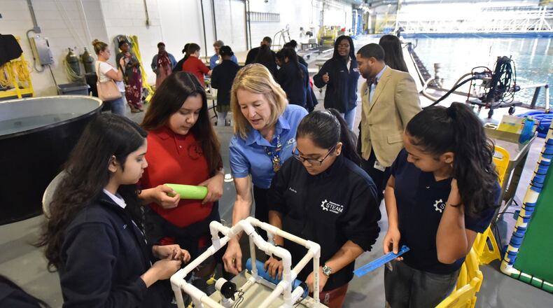 Michelle Norton (center), volunteer, helps students from Sweetwater Middle School as they work on their remotely operated vehicles during Girls Underwater ROV STEM Camp at Georgia Aquarium on Thursday, April 4, 2019. Sixteen Sweetwater girls took part in the camp during spring break. (Hyosub Shin/AJC)
