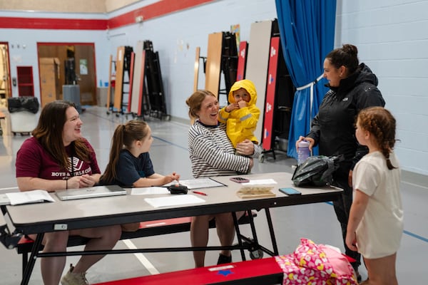 A parent drops their children off at the East Providence Boys and Girls Club Summer Camp at Emma G. Whiteknact Elementary School on Thursday, July 10, 2025, in Providence R.I. (AP Photo/Sophie Park)