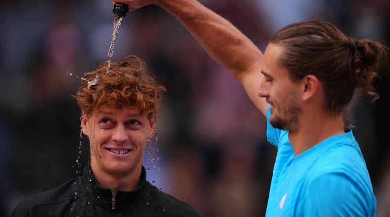 Alexander Zverev, of Germany, right, pours sparkling wine over the head of Jannik Sinner, of Italy, at the end of the men's singles tennis final match against at the Madrid Open tennis tournament in Madrid, Spain, Sunday, May 3, 2026. (AP Photo/Manu Fernandez)