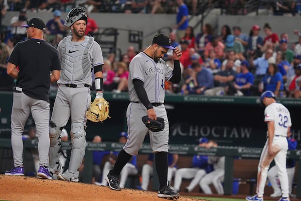 Colorado Rockies starting pitcher Antonio Senzatela, right, leaves play as interim manager Warren Schaeffer, left, and catcher Jacob Stallings stand on the mound during the fifth inning of a baseball game against the Texas Rangers, Wednesday, May 14, 2025, in Arlington, Texas. (AP Photo/LM Otero)