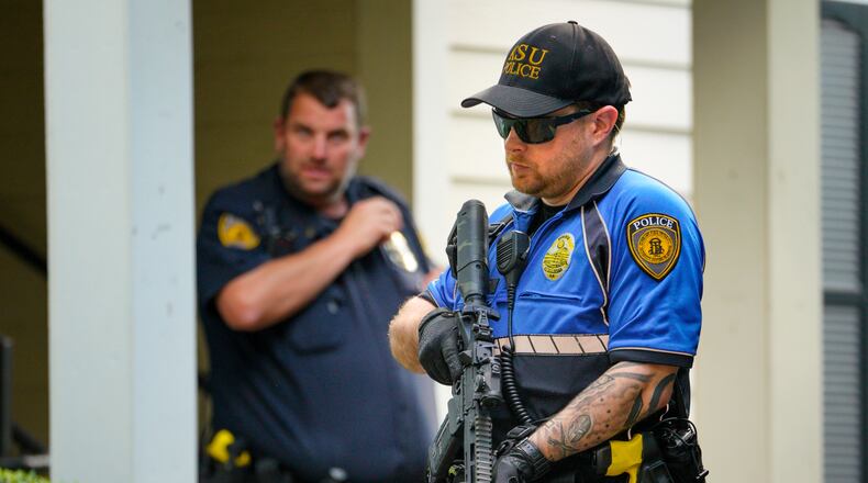 A Kennesaw State University police officer stands armed outside the Austin Residence Complex on Thursday afternoon.