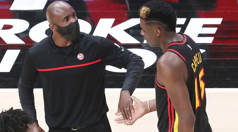 Coach Lloyd Pierce greets Clint Capela during a break in the action in Monday's 112-94 victory over the 76ers at State Farm Arena. Capela finished with 12 points and 11 rebounds, one of six Hawks in double figures.