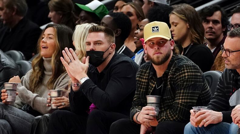 Atlanta Braves first baseman Freddie Freeman, center left, and relief pitcher A.J. Minter, center right, watch the first half of an NBA basketball game between the Atlanta Hawks and the Utah Jazz, Thursday, Nov. 4, 2021, in Atlanta. (AP Photo/John Bazemore)