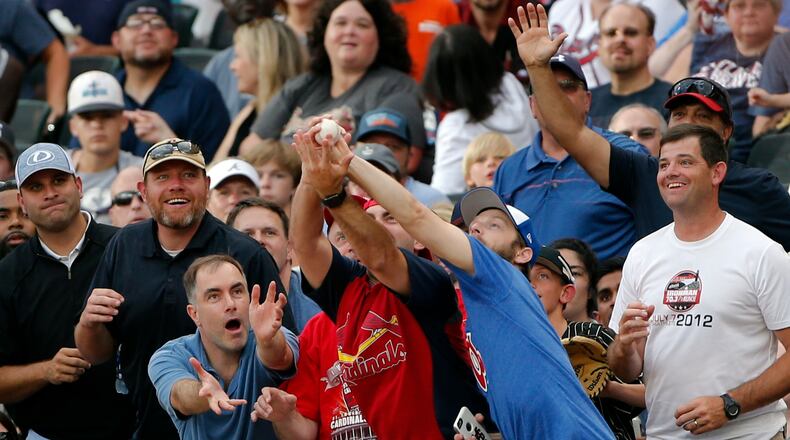 Fans reach for a foul ball during the Braves-Diamondbacks game on Saturday. (AP Photo/John Bazemore)