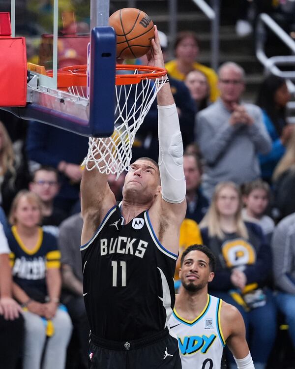 Milwaukee Bucks center Brook Lopez (11) gets a dunk in front of Indiana Pacers guard Tyrese Haliburton (0) during the first half of a first-round NBA basketball playoff game in Indianapolis, Tuesday, April 22, 2025. (AP Photo/Michael Conroy)