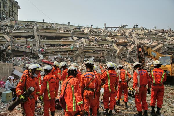 In this photo released by Xinhua News Agency, rescuers prepare to conduct a search and rescue at a collapsed building in the aftermath of an earthquake in Mandalay, Myanmar, Sunday, March 30, 2025. (Myo Kyaw Soe/Xinhua via AP)
