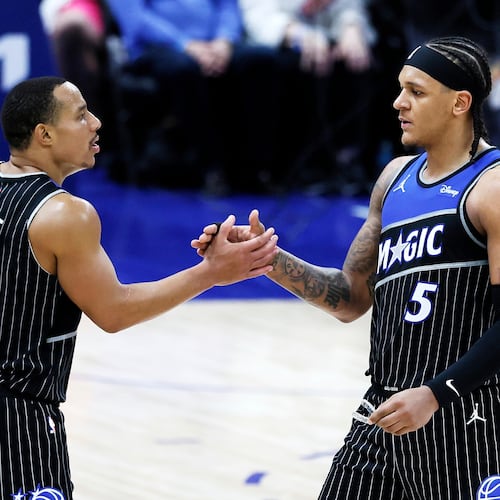 Orlando Magic guard Desmond Bane (3) celebrates with forward Paolo Banchero (5) after a win over the Detroit Pistons in Game 1 of a first-round NBA basketball playoffs series Sunday, April 19, 2026, in Detroit. (AP Photo/Duane Burleson)