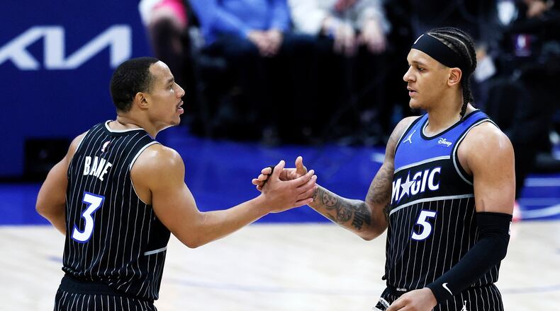 Orlando Magic guard Desmond Bane (3) celebrates with forward Paolo Banchero (5) after a win over the Detroit Pistons in Game 1 of a first-round NBA basketball playoffs series Sunday, April 19, 2026, in Detroit. (AP Photo/Duane Burleson)
