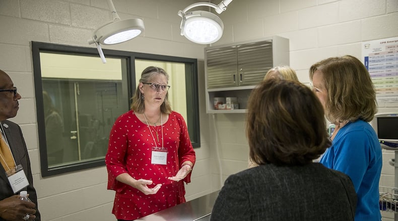 Veterinarian Michelle Goodnight (center), veterinary technology instructor at Gwinnett Technical College, speaks to guests in the newly constructed veterinarian surgical suite at the Grayson Technical Education Program building at Grayson High School in Loganville on Wednesday, Sept. 25, 2019. ALYSSA POINTER/ALYSSA.POINTER@AJC.COM