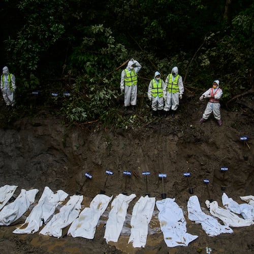 Nepal police personnel prepare the bodies of flash flood victims for a mass burial in Kathmandu, Nepal, Tuesday, Sept. 1, 2026. (AP Photo/Niranjan Shrestha)
