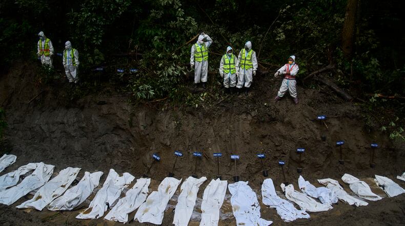 Nepal police personnel prepare the bodies of flash flood victims for a mass burial in Kathmandu, Nepal, Tuesday, Sept. 1, 2026. (AP Photo/Niranjan Shrestha)