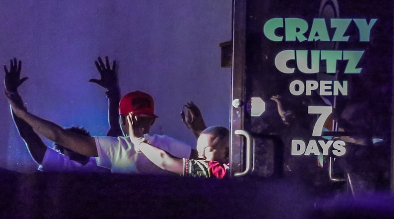 At least three people came out of a northwest Atlanta barbershop with their hands behind their heads hours after police said possibly armed teenagers were held up Mon., June 6, 2016, inside the barbershop. JOHN SPINK / JSPINK@AJC.COM