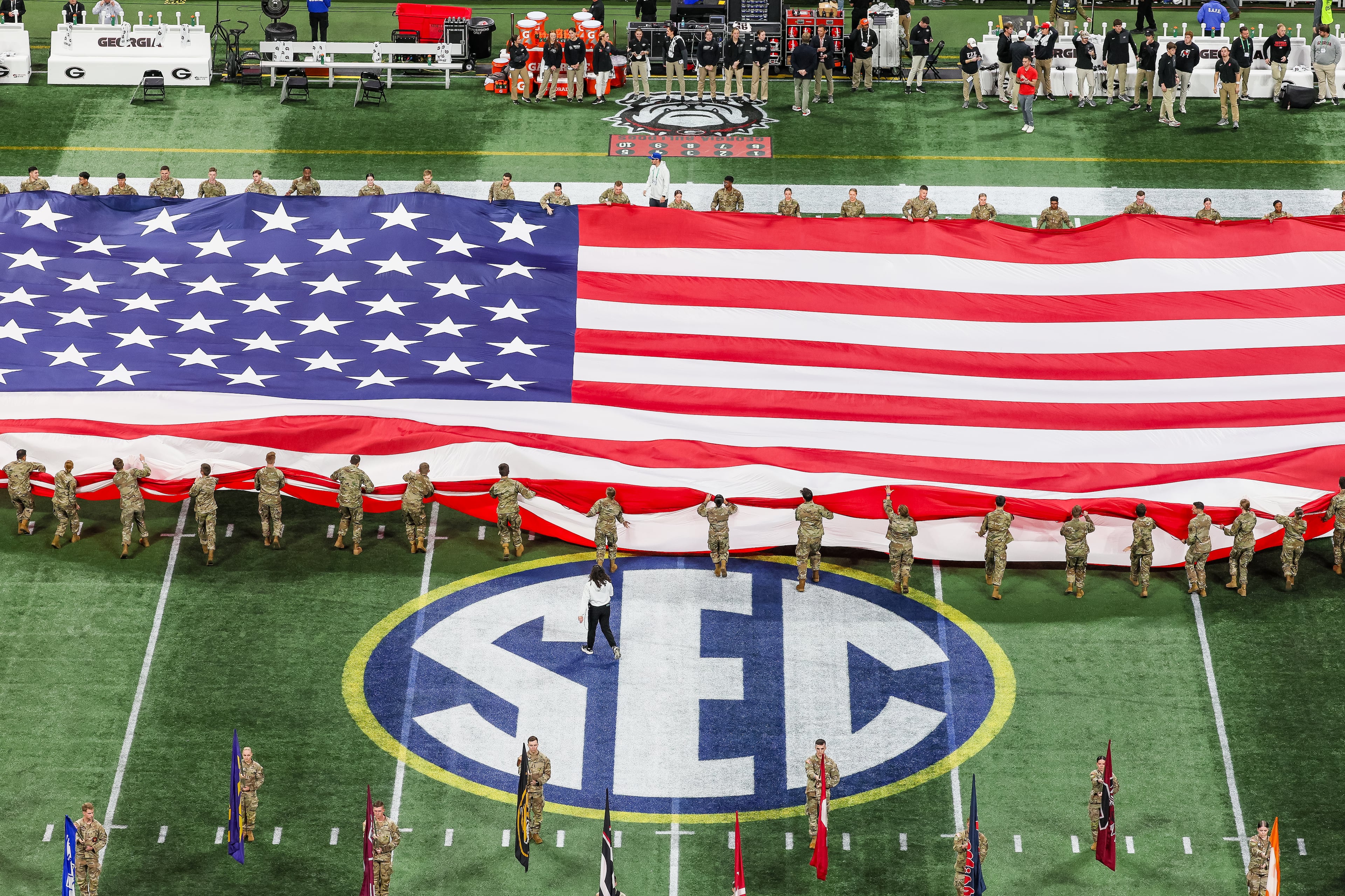 The U.S. flag is unfurled for the national anthem before Georgia faces Alabama in the SEC Championship Game at Mercedes-Benz Stadium, Saturday, Dec. 6, 2025, in Atlanta. (Jason Getz / AJC)